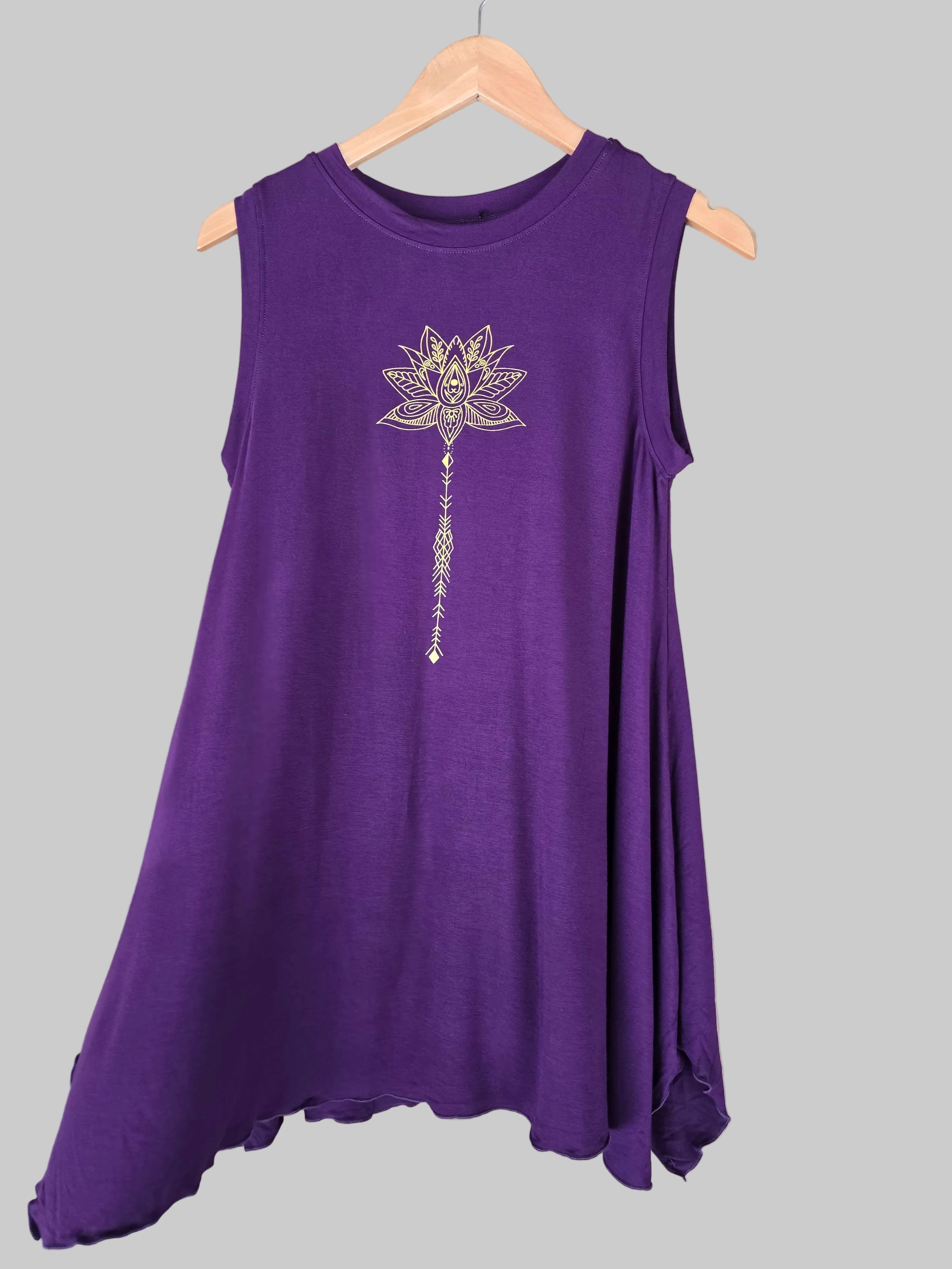 Purple sleeveless dress with a decorative emblem on a hanger against a tiled wall.