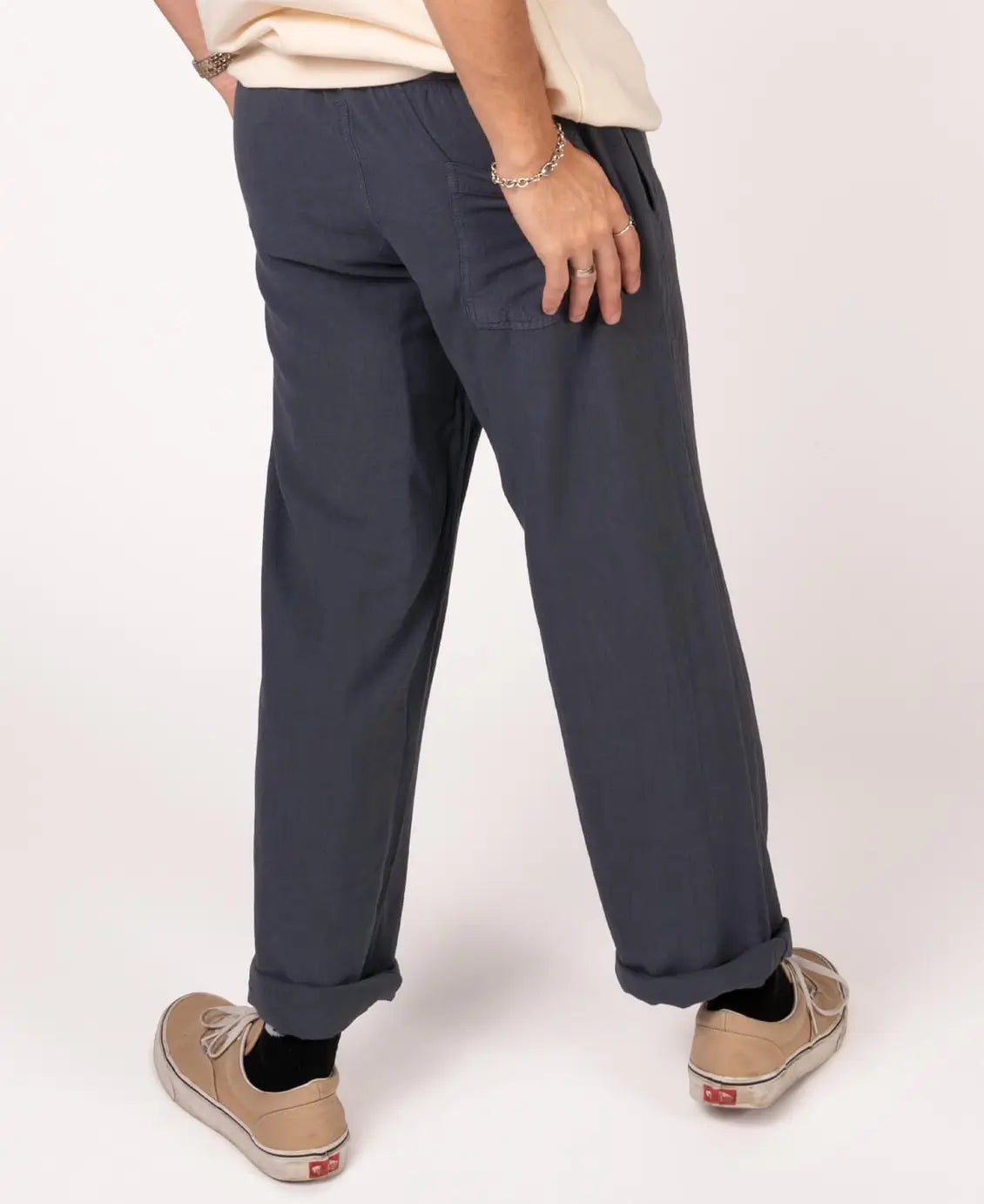 Person wearing navy pants and beige shoes on a white background