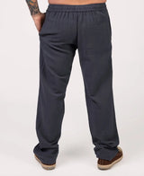 Dark gray pants worn by a person on a white background