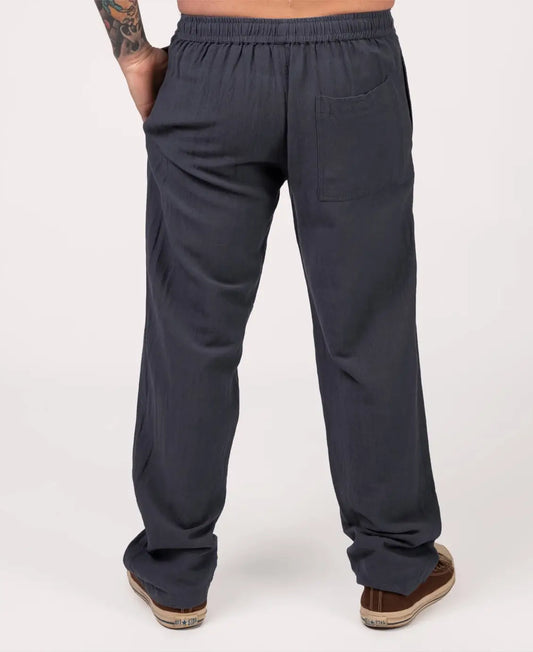 Dark gray pants worn by a person on a white background