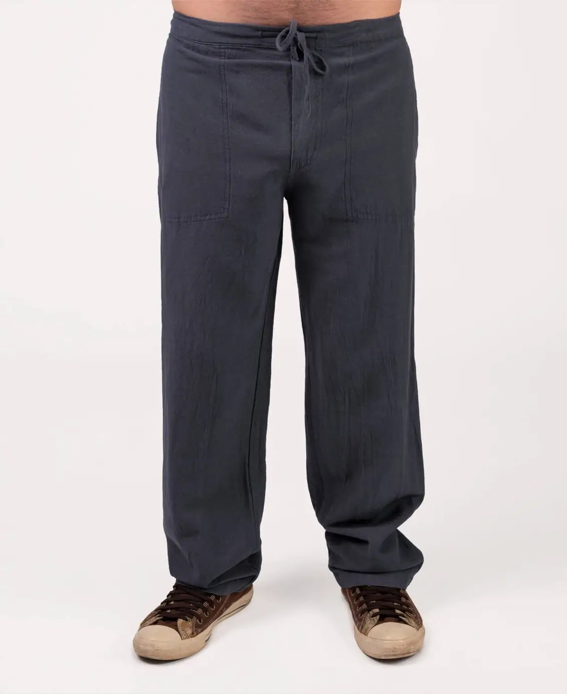 Dark gray pants worn by a person on a white background