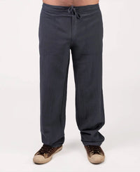 Dark gray pants worn by a person on a white background
