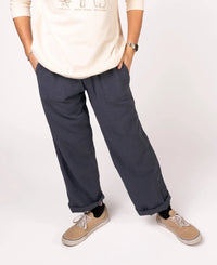 Person wearing navy pants and beige shoes on a white background