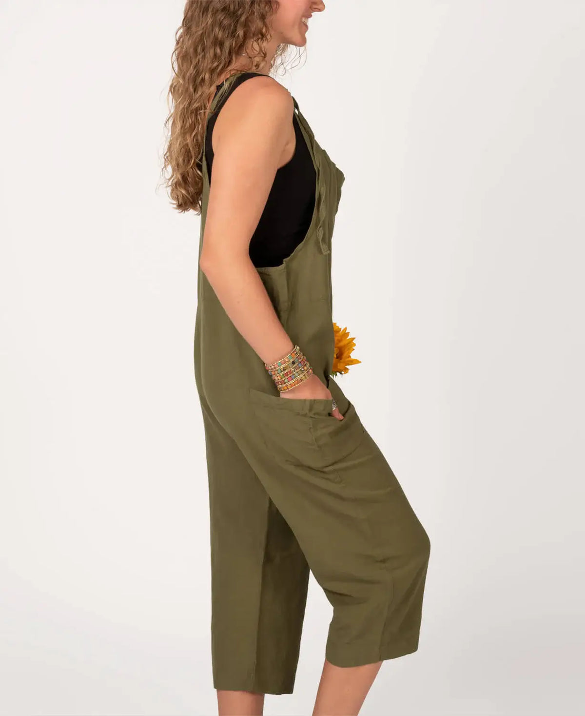 Woman wearing a green jumpsuit with a plain white background