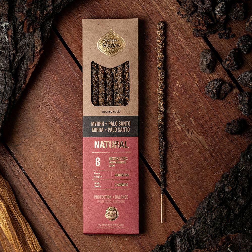 Incense stick packaging on a wooden surface with incense sticks and myrrh resin.