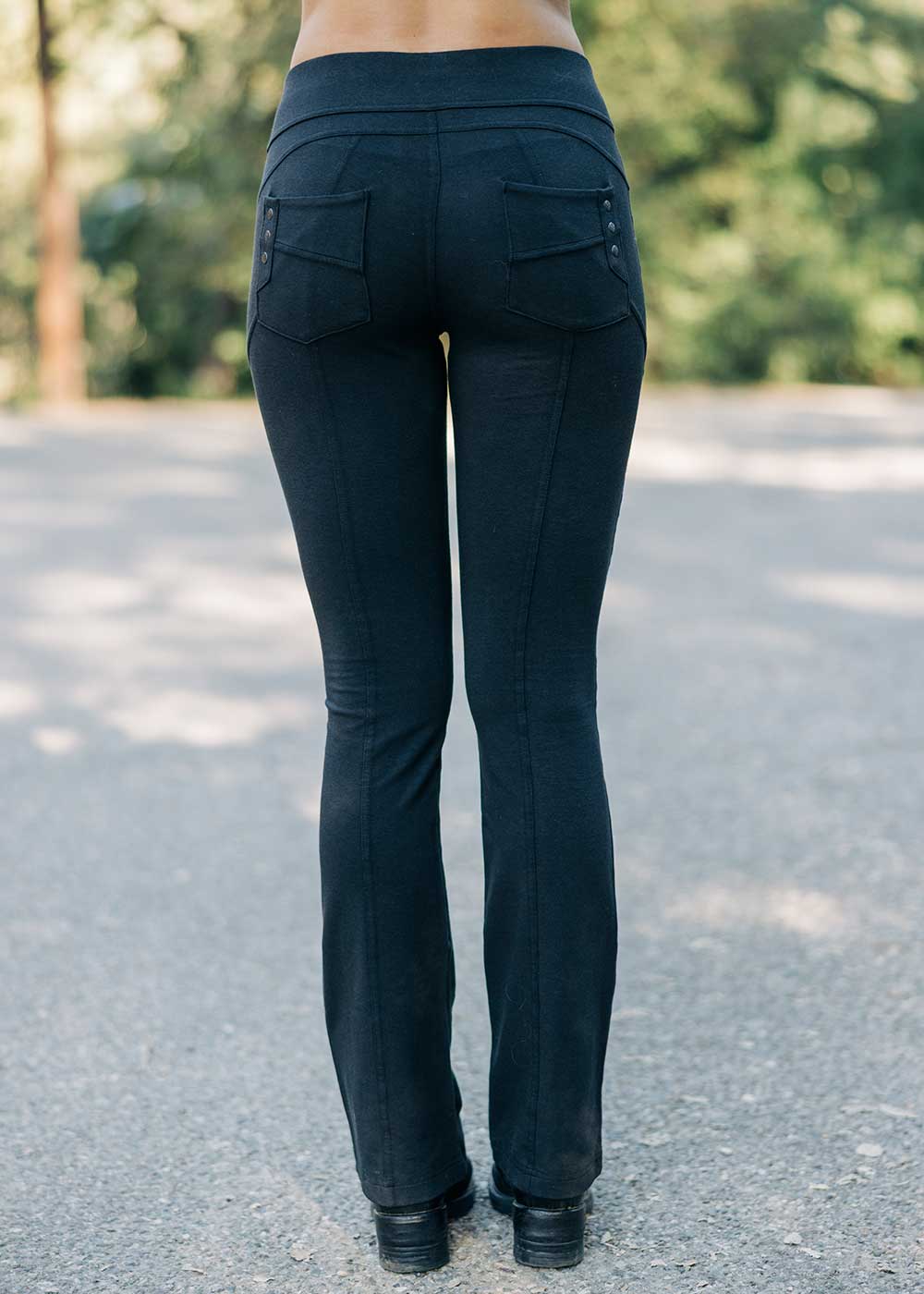 Black pants with multiple pockets worn by a person on a road with greenery in the background
