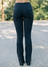 Black pants with multiple pockets worn by a person on a road with greenery in the background