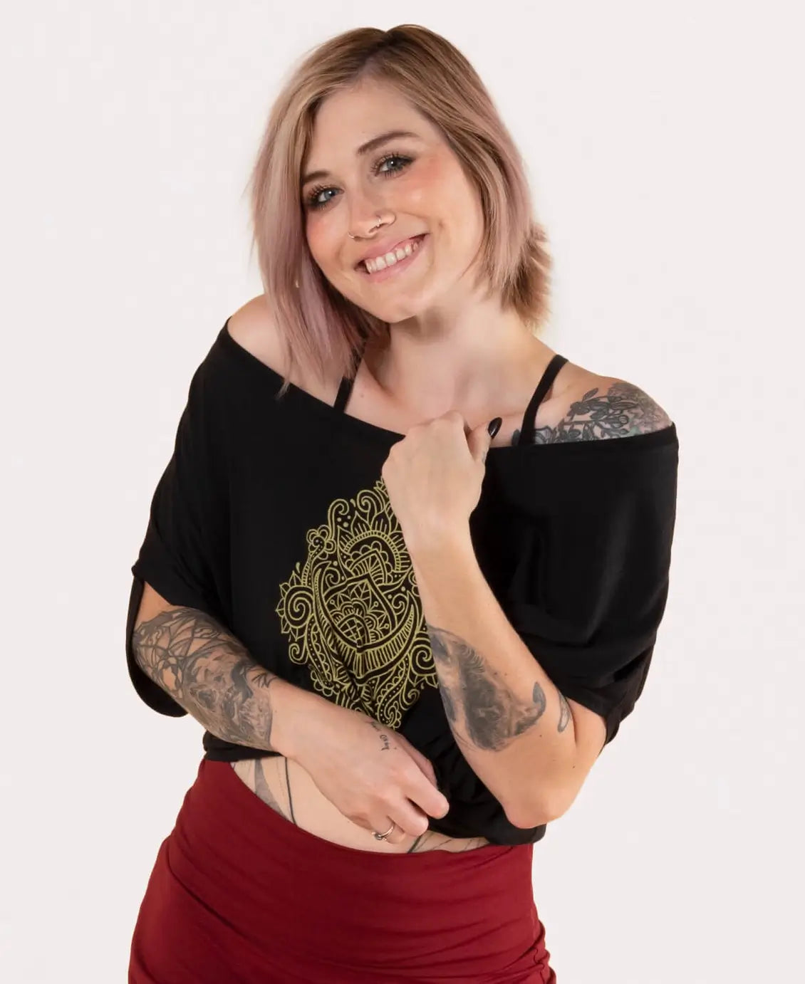 Woman wearing a black top with a gold design on a white background