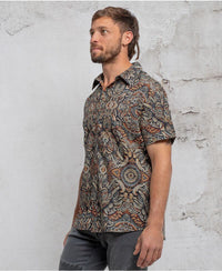 man in a psycadelic owl pattern button-up cotton shirt