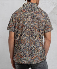 man in a psycadelic owl pattern button-up cotton shirt