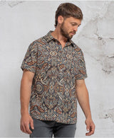 man in a psycadelic owl pattern button-up cotton shirt