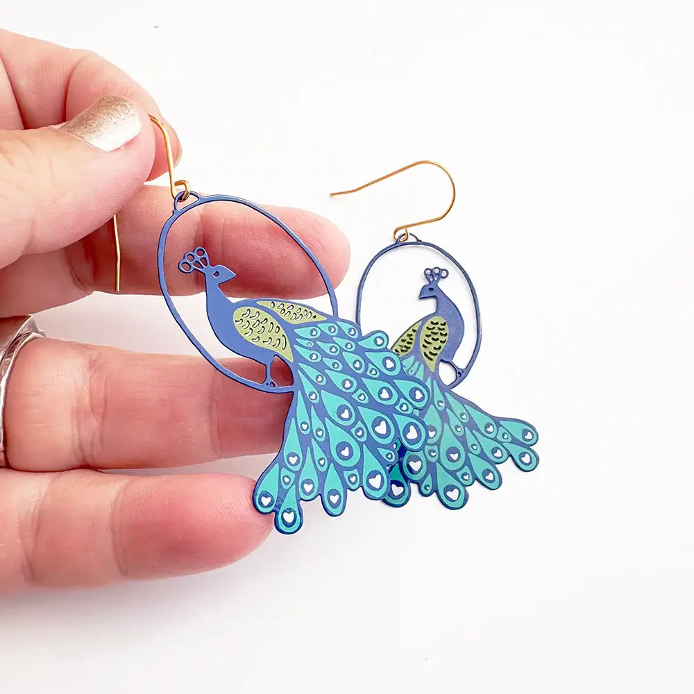 lady wearing earrings with peacock design 