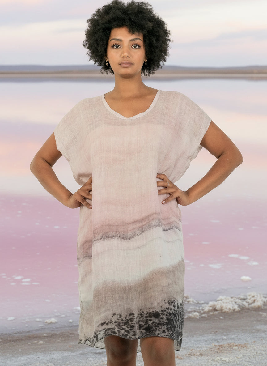 Woman wearing a light pink and gray gradient dress against a  pink salt lake background