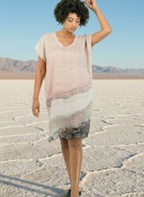 woman in dress with a photo of a pink salt lake on it with a salt lake behind her. 
