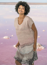 Woman wearing a pink layered dress with a white background