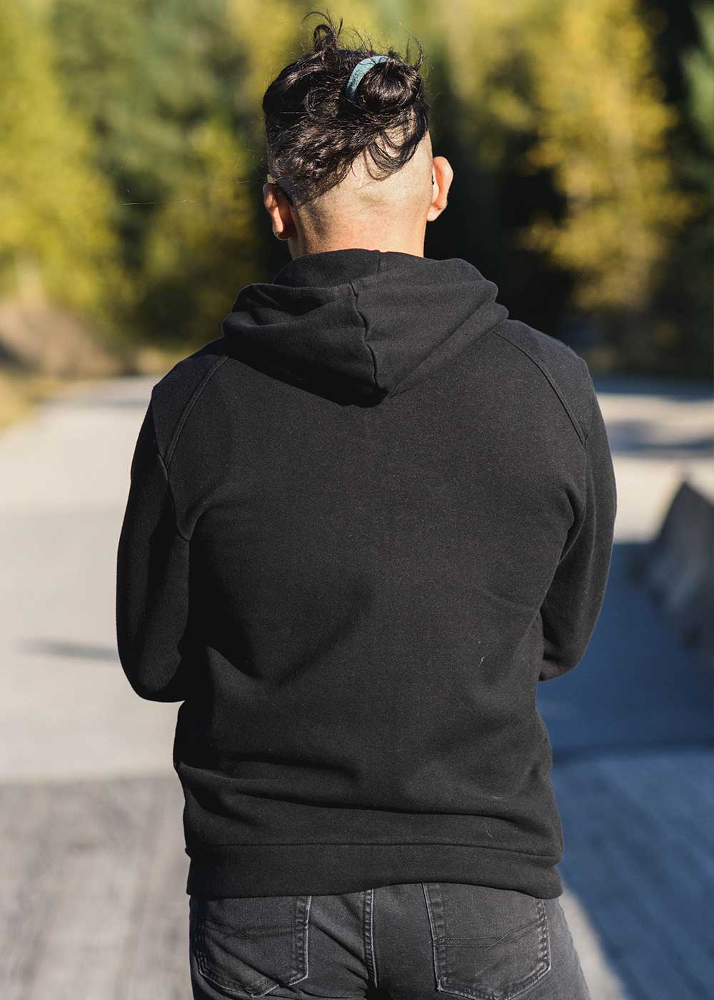 Person wearing a black hoodie with a blurred background