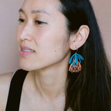 Woman wearing a unique earring with blue and pink design