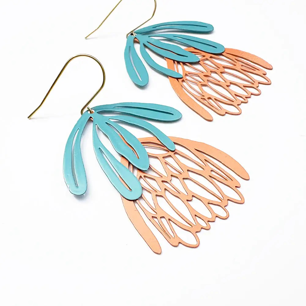 Pair of earrings with blue and rose gold leaf-like designs on a white background
