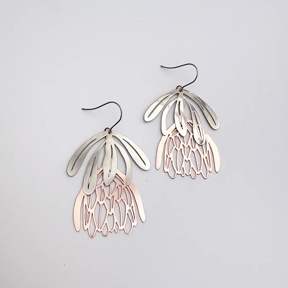 Pair of silver and rose gold earrings on a light gray background