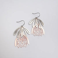 Pair of silver and rose gold earrings on a light gray background