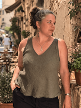Woman standing on a street with stone buildings and potted plants