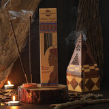 Incense sticks with packaging on a wooden platform, surrounded by candles and decorative elements.