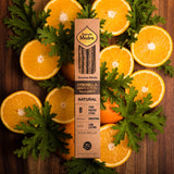 Box of Incense Sticks with Citronella, Orange Peel, and Palo Santo surrounded by sliced oranges and leaves on a wooden background.