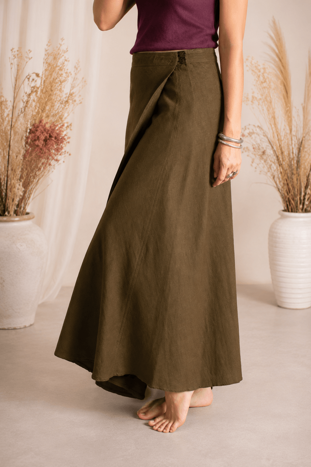 Person wearing a long olive green skirt with a blurred background