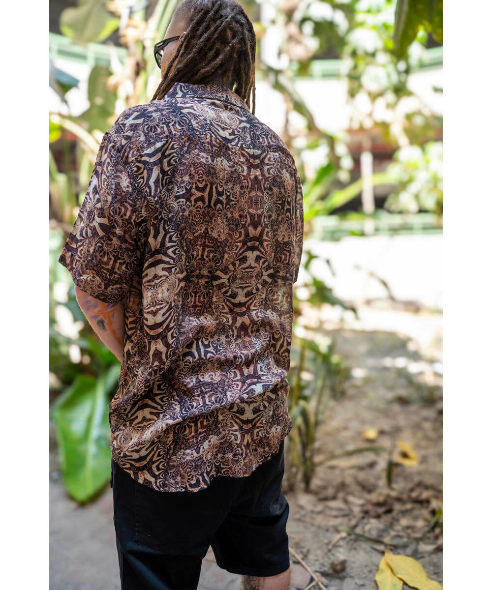 Person wearing a patterned shirt in a natural setting