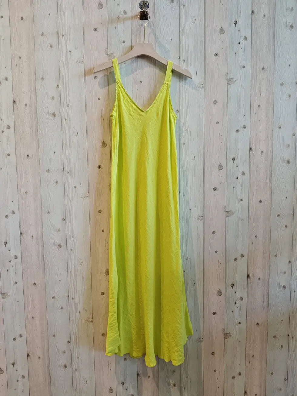 canary yellow dress haningn on the wall 
