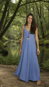 lady in blue dress by a river with lots of dshady trees
