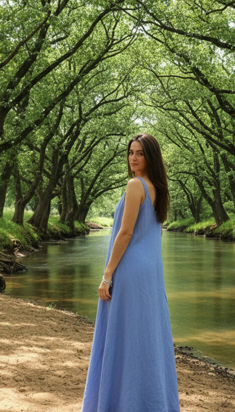 lady in blue dress by the river with shady trees
