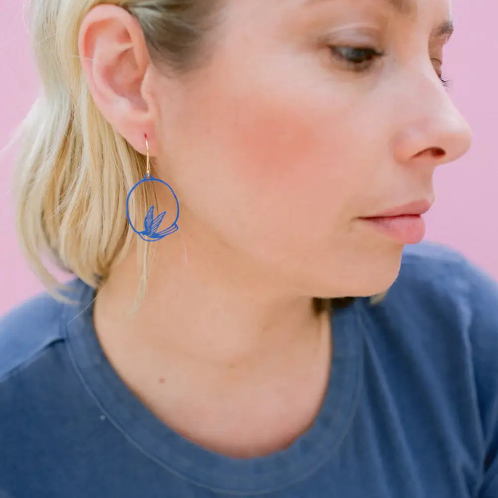 lady wearing blue swollow earrings