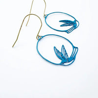 lady wearing blue swollow earrings