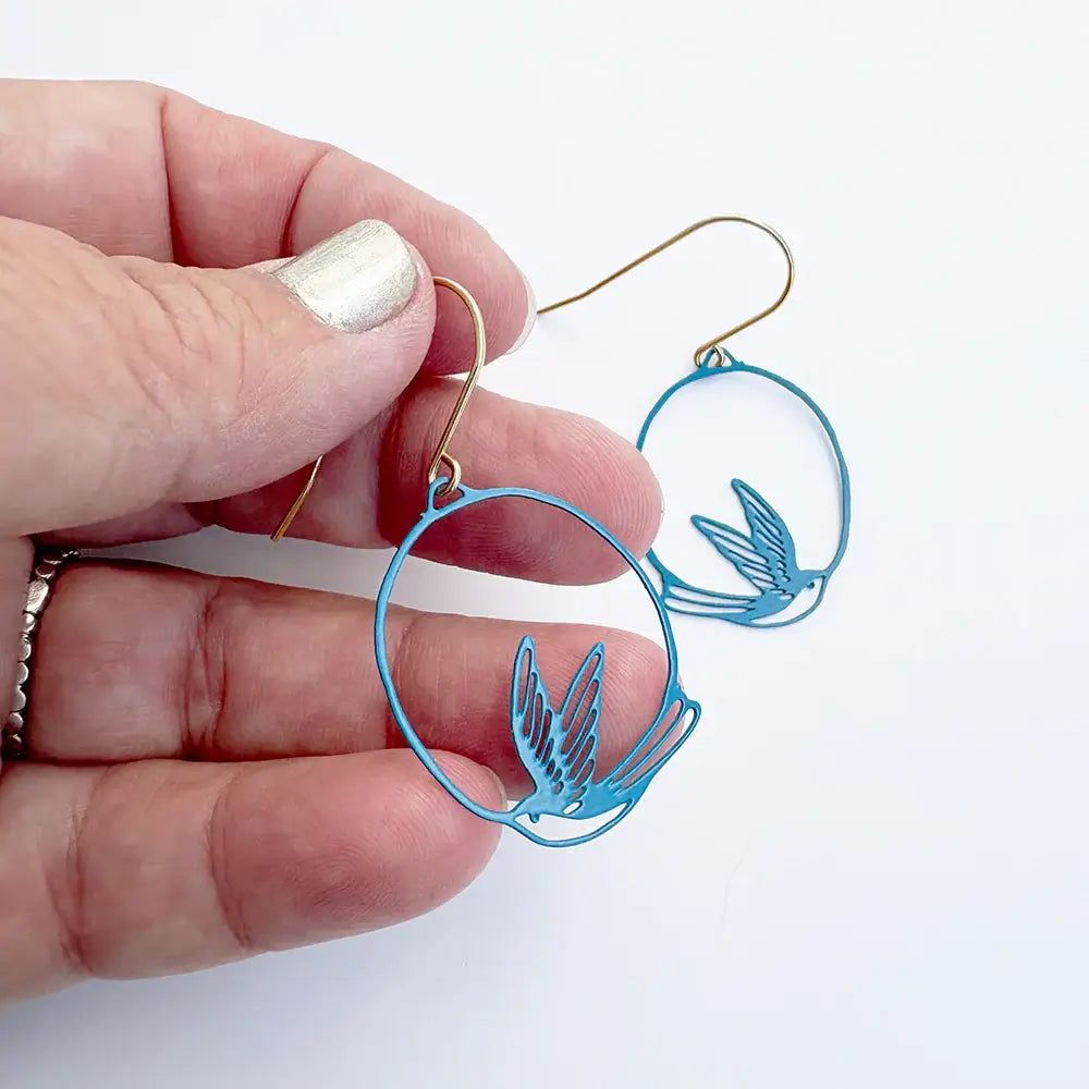 lady wearing blue swollow earrings