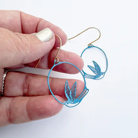 lady wearing blue swollow earrings