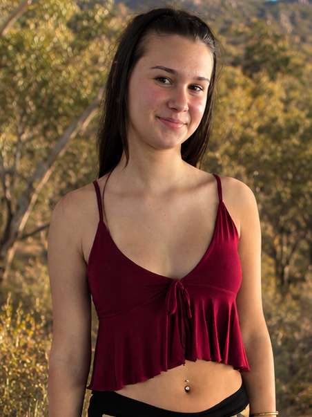 Woman standing in a natural setting with trees and mountains in the background