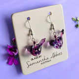 Purple glass earrings on a card with 'Glass by Samantha Abbott Australia' text, against a purple background.