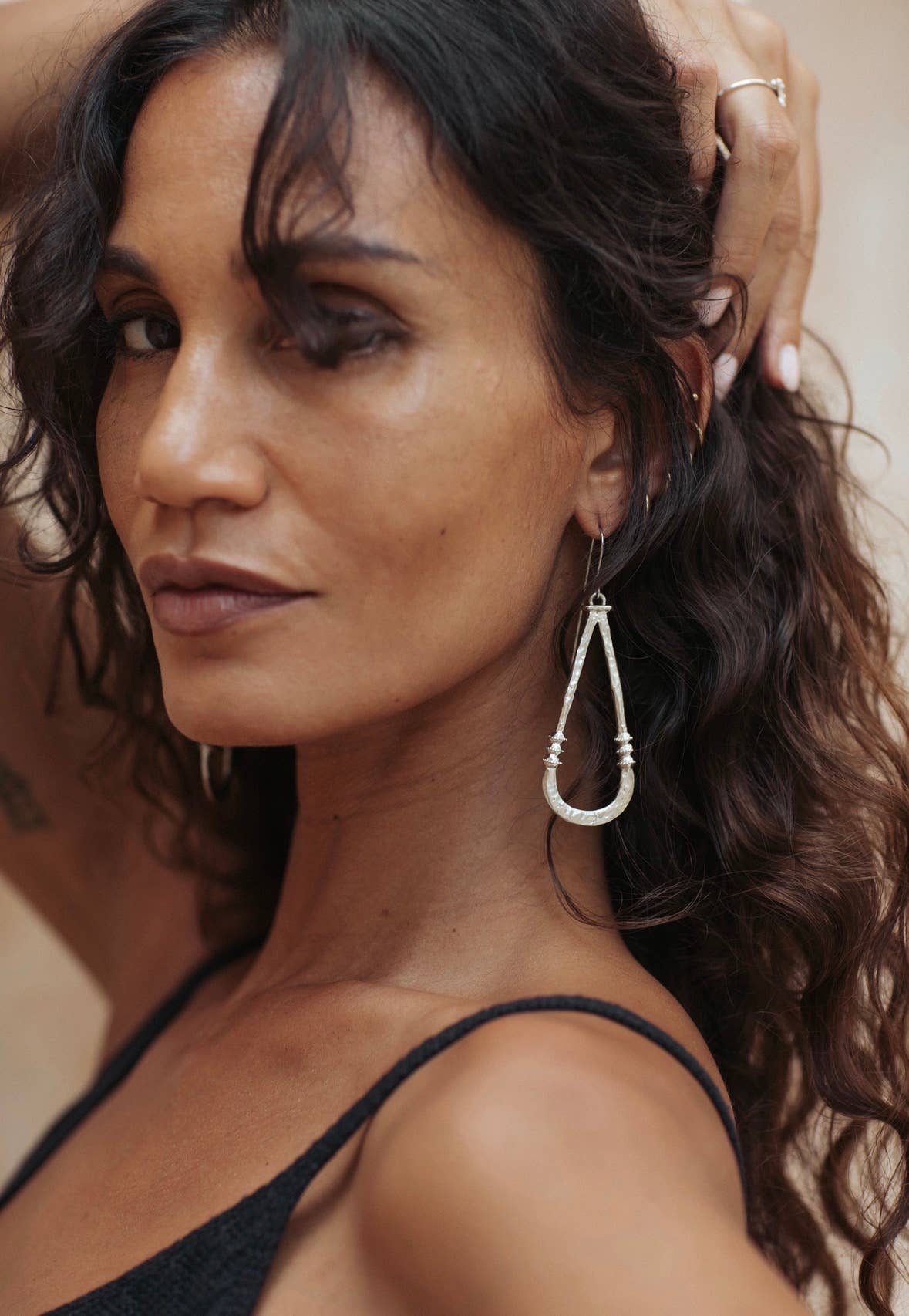 Shop Zuri Earrings in white brass with sterling silver hooks, featuring a long sculptural shape, hammered texture and lightweight feel.